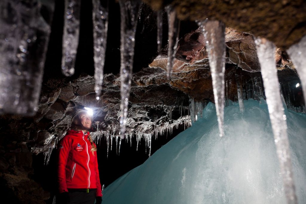 Une personne observe avec émerveillement l'intérieur d'une grotte de lave en Islande