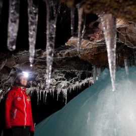 Une personne observe avec émerveillement l'intérieur d'une grotte de lave en Islande