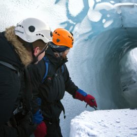 Deux hommes regardant dans une crevasse sur un glacier en Islande