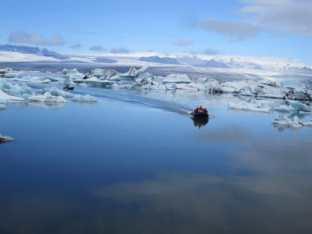 Photo aérienne d'un zodiac de face dans le lagon aux icebergs