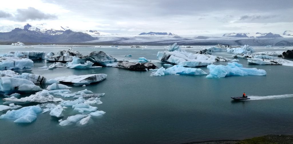 Photo aérienne d'un zodiac dans le lagon aux icebergs
